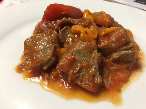 Carne cocida con tomate y pimiento